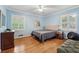 Comfortable bedroom showcasing beautiful hardwood floors, blue walls, and natural lighting from the bright windows at 500 Read Ln, Atlanta, GA 30328