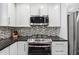 Modern kitchen features granite countertops, mosaic tile backsplash, stainless steel appliances and gas cooktop at 500 Read Ln, Atlanta, GA 30328
