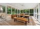 Relaxing screened porch with wooden flooring, a ceiling fan, and a dining table for outdoor entertaining at 500 Read Ln, Atlanta, GA 30328