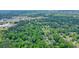 An aerial view displays lush greenery with a mix of residential and commercial properties nestled among the trees at 588 Benson Hurst Sw Dr, Mableton, GA 30126