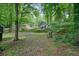 View of the home's backyard, fenced in and surrounded by mature trees at 588 Benson Hurst Sw Dr, Mableton, GA 30126