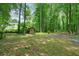 Large backyard featuring mature trees, a storage shed and plenty of space for outdoor activities at 588 Benson Hurst Sw Dr, Mableton, GA 30126