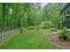 Spacious backyard with a mix of lush lawn, trees, garden, and patio seating, great for outdoor activities at 588 Benson Hurst Sw Dr, Mableton, GA 30126