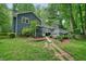 Charming backyard featuring a well-maintained lawn, garden beds, and a serene wooded backdrop at 588 Benson Hurst Sw Dr, Mableton, GA 30126