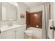 Bathroom featuring a tub with brown tiles, single sink vanity, and large mirror at 588 Benson Hurst Sw Dr, Mableton, GA 30126