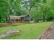 Charming exterior view of a home featuring brick accents, lush green landscaping, and mature trees at 588 Benson Hurst Sw Dr, Mableton, GA 30126