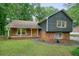 Charming home with a lush green yard, stone and brick details, and wood siding at 588 Benson Hurst Sw Dr, Mableton, GA 30126
