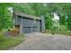 Two-car garage with additional parking space, set against a backdrop of mature trees at 588 Benson Hurst Sw Dr, Mableton, GA 30126