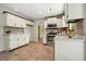 Well-lit kitchen featuring white cabinetry, stainless steel appliances, and tiled floors and backsplash at 588 Benson Hurst Sw Dr, Mableton, GA 30126