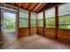 Enclosed porch with wood flooring and a view of the wooded surrounding yard at 588 Benson Hurst Sw Dr, Mableton, GA 30126