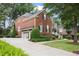 Side view of a well-maintained brick home with a long driveway and attached garage at 2630 Weddington Ne Pl, Marietta, GA 30068
