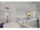 Bright hallway with a decorative chandelier, iron railing, and recessed lighting showcasing architectural detail at 2630 Weddington Ne Pl, Marietta, GA 30068