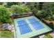 Aerial view of community tennis courts featuring pristine blue courts, lush trees and seating at 2630 Weddington Ne Pl, Marietta, GA 30068
