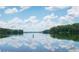 Scenic lake view with reflections of clouds on the water's surface, surrounded by lush greenery at 313 Willow Cv, Canton, GA 30114