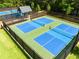 Multiple blue and green pickleball courts, fenced, with a covered gazebo for players' use in a park-like setting at 313 Willow Cv, Canton, GA 30114