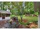 Serene backyard with a wooden deck, outdoor dining, and a tranquil view of the surrounding greenery at 4507 Reva Way, Marietta, GA 30066