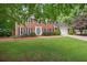 Traditional brick home with black shutters, a well-kept lawn, and lush green trees at 4507 Reva Way, Marietta, GA 30066