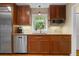 Well-lit kitchen boasts wood cabinets, a granite countertop, stainless steel appliances, and a tiled backsplash at 4507 Reva Way, Marietta, GA 30066
