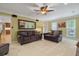 A well-lit living room featuring a carpet, brown leather furniture, decor, and large mirror reflecting natural light at 4507 Reva Way, Marietta, GA 30066
