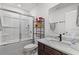 Clean bathroom with a dark vanity, white tile, and a shower-tub combination with glass doors at 507 Bishop Ln, Woodstock, GA 30188