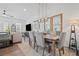 Open-concept living and dining area with a rustic dining table, pendant lights, and a view into the living room at 507 Bishop Ln, Woodstock, GA 30188