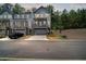 Charming two-story townhome with a stone-accented base, private porch, and driveway at 507 Bishop Ln, Woodstock, GA 30188