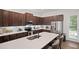 Well-lit kitchen features stainless steel appliances, granite countertops, a center island, and brown cabinetry at 507 Bishop Ln, Woodstock, GA 30188