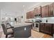 Open concept kitchen with stainless steel appliances, a breakfast bar, granite countertops, and dark brown cabinets at 507 Bishop Ln, Woodstock, GA 30188