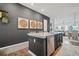 View of the kitchen island with dark gray base and white countertop, open to a living and dining area with artwork at 507 Bishop Ln, Woodstock, GA 30188