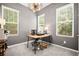 Bright office with a large wooden desk, modern lighting, and three large windows at 507 Bishop Ln, Woodstock, GA 30188