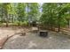 Backyard fire pit and swing area, surrounded by a gravel base, with lush landscaping and trees at 59 Grand Georgian Ne Ct, Cartersville, GA 30121