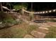 Landscaped backyard patio featuring stone pavers, string lights, and outdoor furniture at 59 Grand Georgian Ne Ct, Cartersville, GA 30121