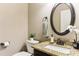 Well-lit powder room with a granite countertop, decorative mirror, and stylish fixtures at 59 Grand Georgian Ne Ct, Cartersville, GA 30121
