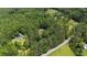 Aerial view showcases a wooded lot near a charming home, offering a blend of privacy and neighborhood charm at 712 Honeysuckle Ln, Temple, GA 30179