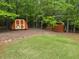 A grassy, wooded backyard features multiple storage sheds at 712 Honeysuckle Ln, Temple, GA 30179