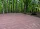 Spacious deck overlooks a serene backyard setting with a picnic table in the distance at 712 Honeysuckle Ln, Temple, GA 30179