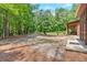 Spacious backyard features a gravel area, patio and seating nestled among mature trees, offering privacy and natural beauty at 712 Honeysuckle Ln, Temple, GA 30179