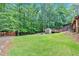 Green backyard featuring multiple storage sheds and a large deck for outdoor entertaining at 712 Honeysuckle Ln, Temple, GA 30179