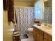 Bathroom with shower and tub combo, white vanity, and a light-patterned shower curtain at 712 Honeysuckle Ln, Temple, GA 30179