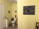 Bathroom area with toilet, wall art, yellow paint and door at 712 Honeysuckle Ln, Temple, GA 30179