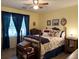 A bedroom featuring a bed with dark-blue trim, yellow walls and wooden furniture at 712 Honeysuckle Ln, Temple, GA 30179