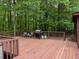 Deck features railing, chairs, grill, and natural views into the surrounding woods at 712 Honeysuckle Ln, Temple, GA 30179