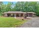 Charming single-story home with a welcoming front porch and spacious front yard nestled among mature trees at 712 Honeysuckle Ln, Temple, GA 30179
