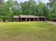 Charming single-story home featuring a well-manicured lawn and mature trees at 712 Honeysuckle Ln, Temple, GA 30179