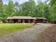 Cozy home with a gravel driveway surrounded by lush greenery, offering a serene setting at 712 Honeysuckle Ln, Temple, GA 30179