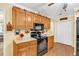 Kitchen with oak cabinets and black appliances including a range, oven, and microwave at 712 Honeysuckle Ln, Temple, GA 30179