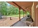 Relaxing covered porch area featuring comfortable seating and views of the lush backyard and surrounding greenery at 712 Honeysuckle Ln, Temple, GA 30179