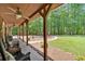 Inviting covered porch with seating, ceiling fans, and views of the landscaped yard and surrounding trees at 712 Honeysuckle Ln, Temple, GA 30179