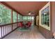 Enclosed back porch with wood floors, dining area, and view of the lush surrounding trees at 712 Honeysuckle Ln, Temple, GA 30179