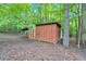 Well-maintained storage shed nestled in a wooded backyard at 712 Honeysuckle Ln, Temple, GA 30179
